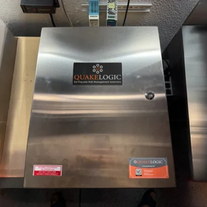 QuakeLogic stainless steel NEMA 4X secondary enclosure housing a SATURN seismic switch installation