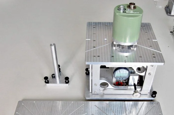A compact, motor-free seismic sensor calibration table with micrometer precision, modeled after the Lennartz CT-EW1 design for testing accelerographs and seismographs.